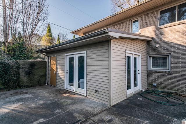 exterior space with fence, brick siding, and a patio area