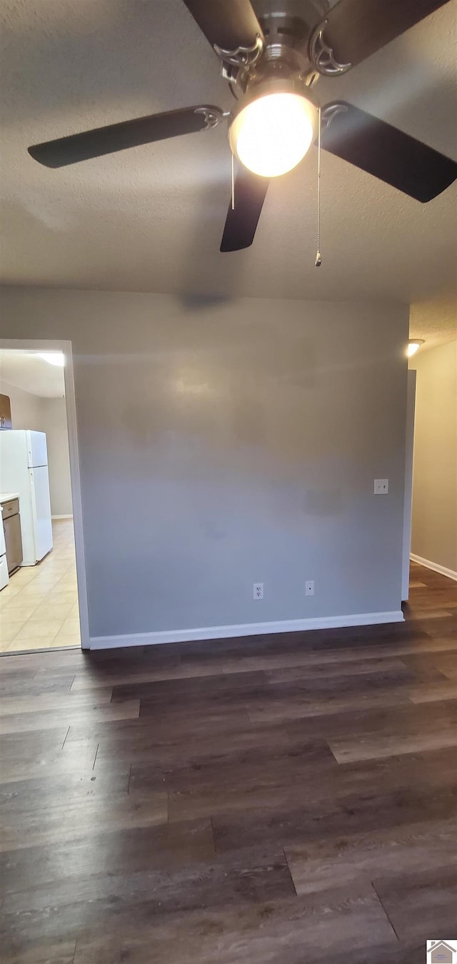 spare room featuring baseboards, a textured ceiling, ceiling fan, and wood finished floors