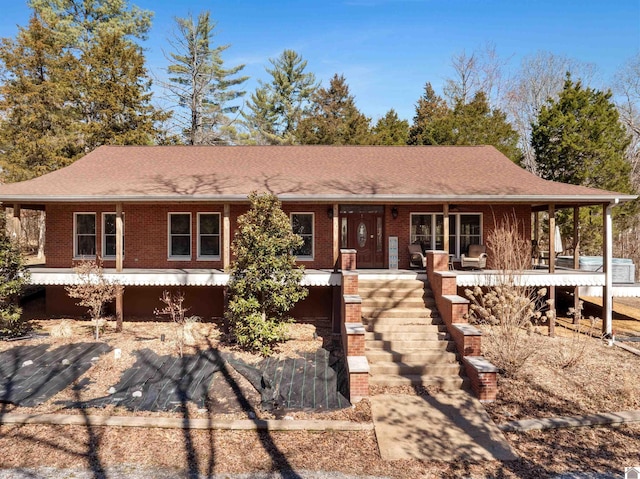 view of front of house featuring brick siding, a porch, and roof with shingles