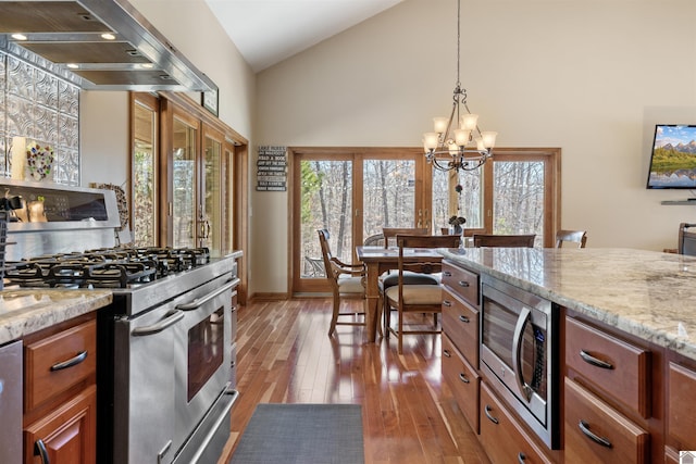 kitchen featuring light wood-style flooring, appliances with stainless steel finishes, extractor fan, a healthy amount of sunlight, and a chandelier