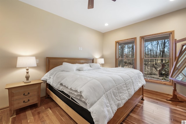 bedroom featuring recessed lighting, baseboards, wood-type flooring, and ceiling fan