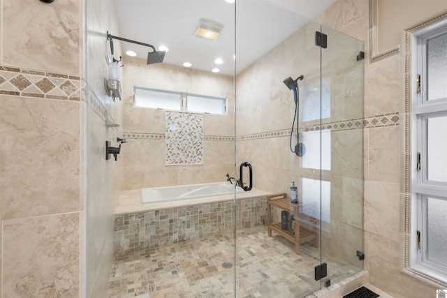 bathroom with tiled tub and a stall shower