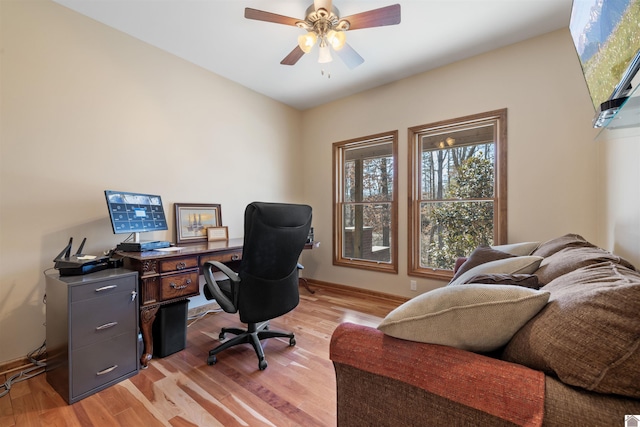 office area with light wood finished floors, ceiling fan, and baseboards