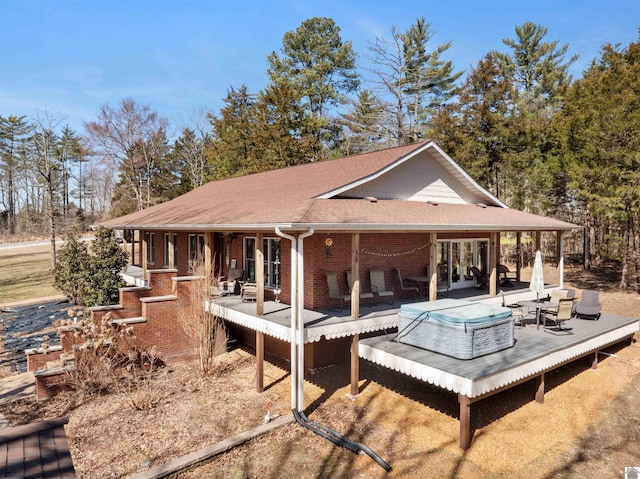 back of house with french doors, brick siding, and roof with shingles