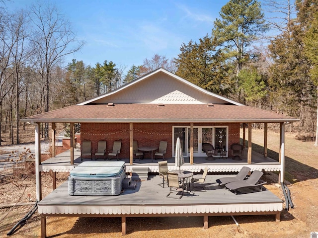 back of house with a wooden deck, brick siding, and a shingled roof