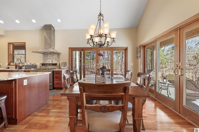 dining space featuring light wood finished floors, a chandelier, recessed lighting, and french doors