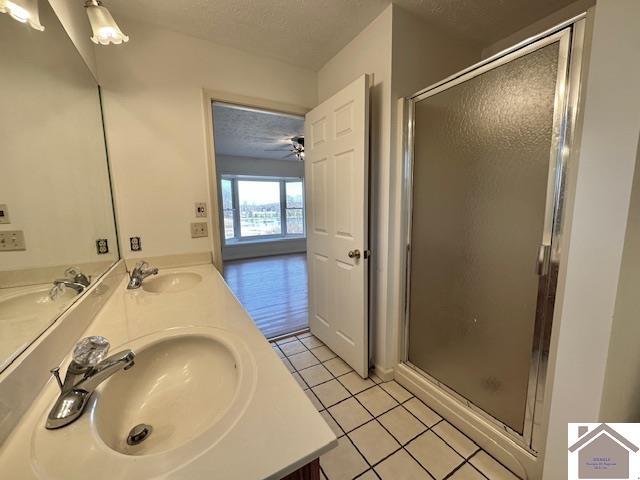 bathroom with tile patterned floors, a textured ceiling, and a sink