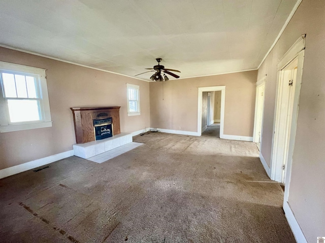 unfurnished living room with visible vents, a healthy amount of sunlight, and carpet flooring