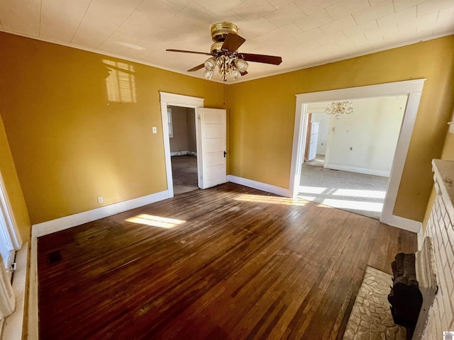 interior space with baseboards, wood finished floors, a ceiling fan, and ornamental molding