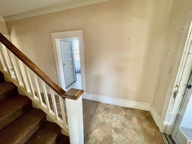 entryway featuring stairs, ornamental molding, baseboards, and stone finish flooring