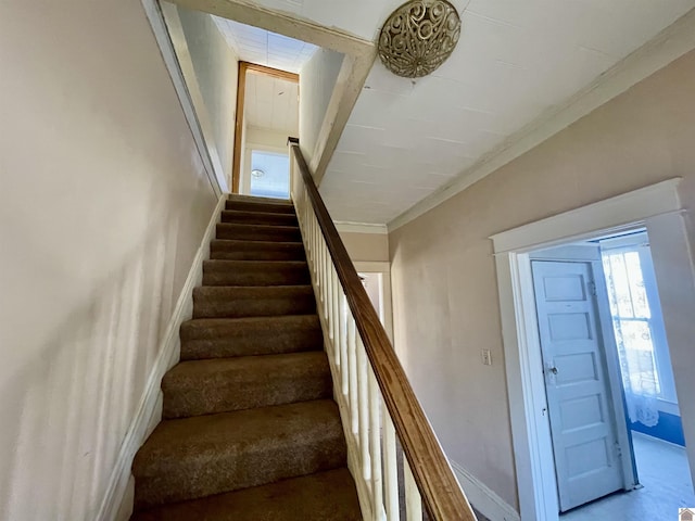 stairway featuring crown molding and baseboards