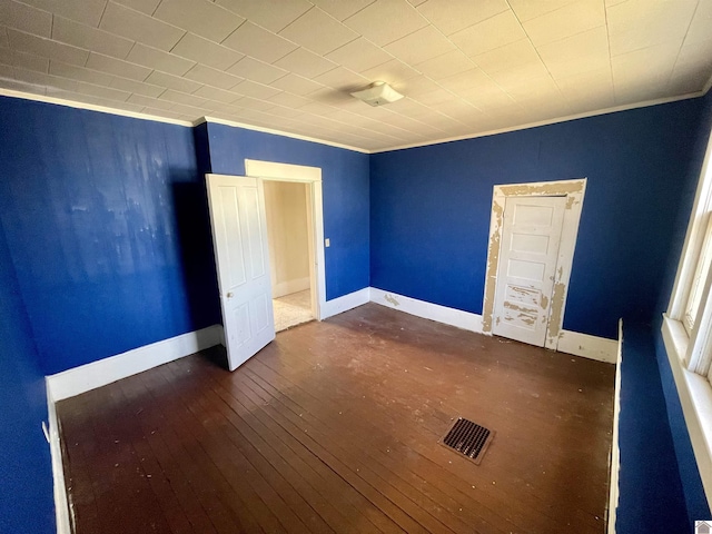 unfurnished bedroom with baseboards, wood-type flooring, and ornamental molding