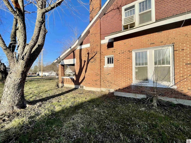 view of side of property featuring brick siding and a chimney