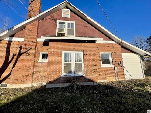 view of property exterior with brick siding and a chimney