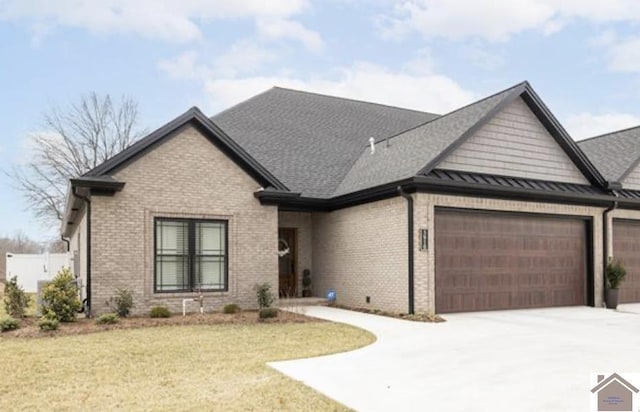 view of front of house featuring brick siding, an attached garage, driveway, and a front yard