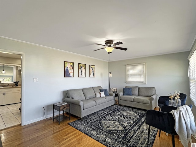 living room featuring a healthy amount of sunlight, light wood-style flooring, and ornamental molding