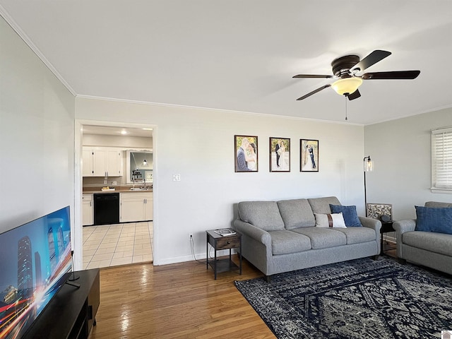 living room featuring light wood-style flooring, baseboards, crown molding, and ceiling fan