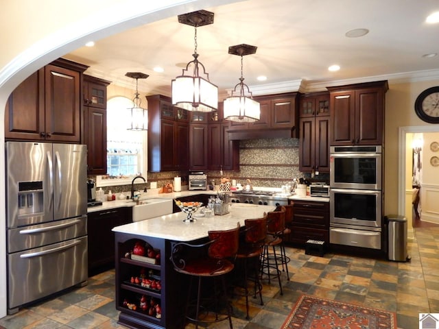 kitchen featuring backsplash, light countertops, stainless steel appliances, a warming drawer, and a sink