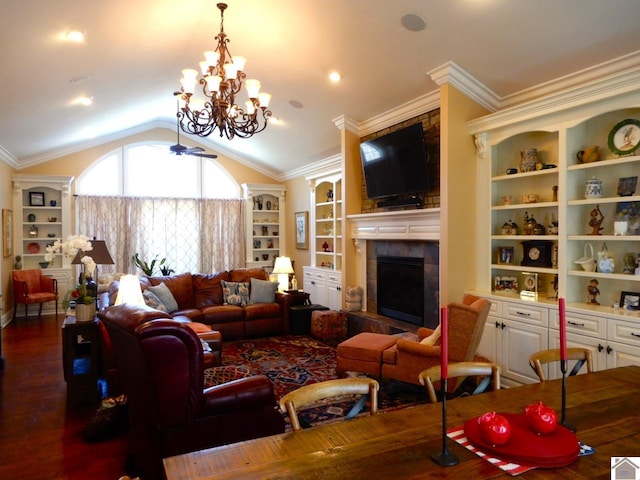 living room with built in features, wood finished floors, crown molding, lofted ceiling, and a tile fireplace