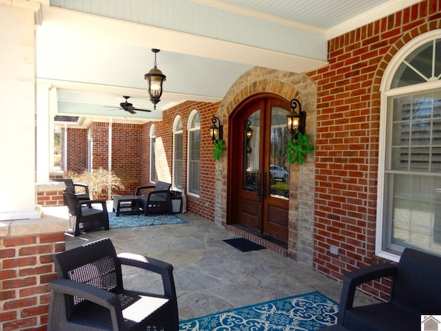 view of exterior entry with covered porch, french doors, and ceiling fan