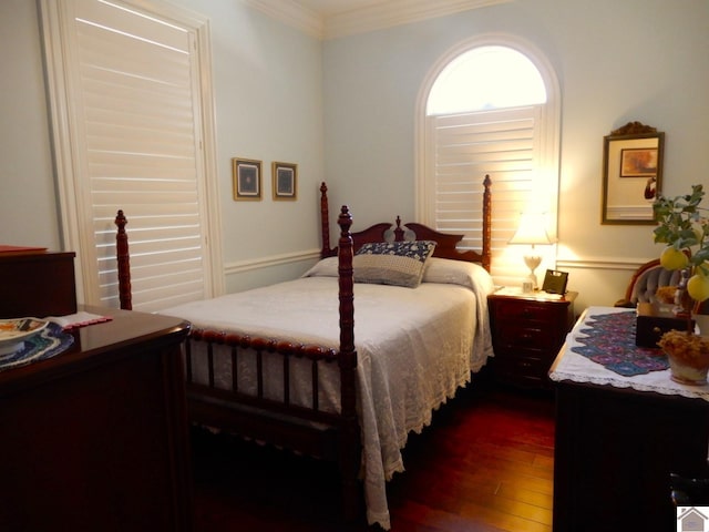 bedroom featuring crown molding and dark wood-style flooring