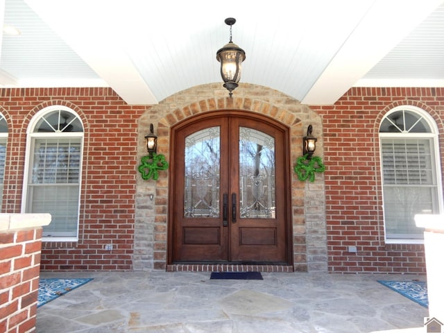 view of exterior entry with french doors and brick siding