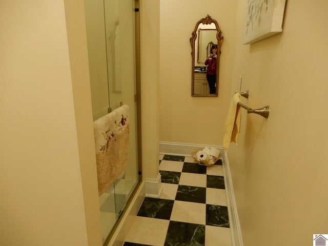 corridor with tile patterned floors and baseboards