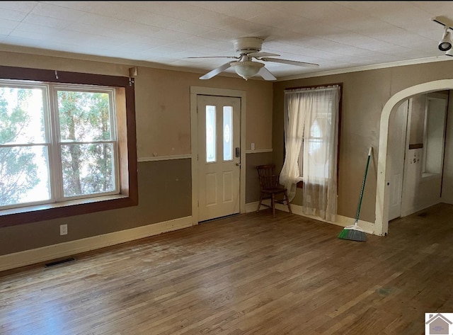 entryway featuring arched walkways, visible vents, baseboards, and wood finished floors