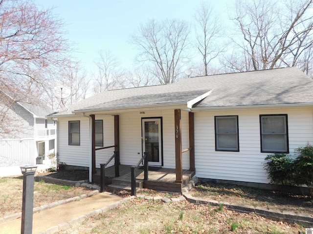 ranch-style house featuring a porch and roof with shingles