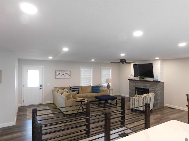 living room featuring recessed lighting, baseboards, wood finished floors, and a fireplace