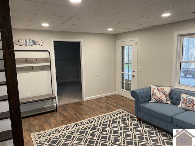 living room featuring recessed lighting, a paneled ceiling, baseboards, and wood finished floors