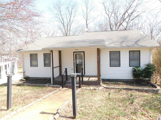 ranch-style house featuring a porch and roof with shingles