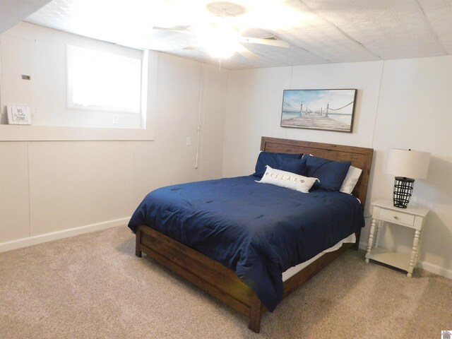 bedroom with a ceiling fan, baseboards, and carpet floors