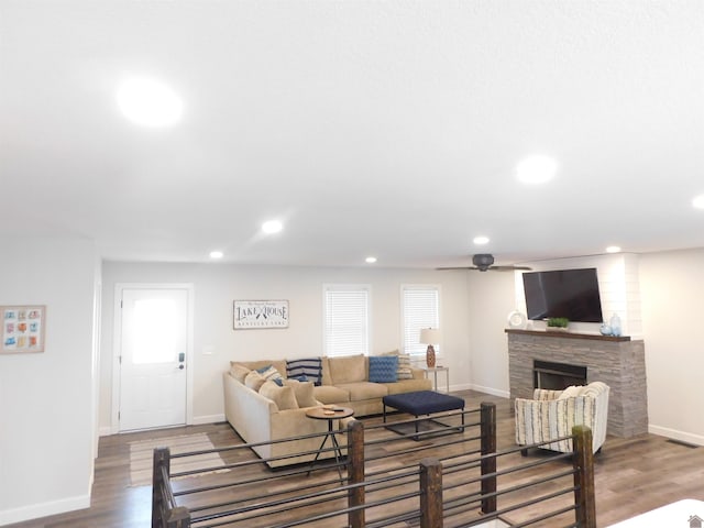 living room with a fireplace, recessed lighting, wood finished floors, and baseboards