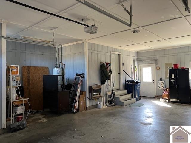 garage with a garage door opener, water heater, and black refrigerator with ice dispenser