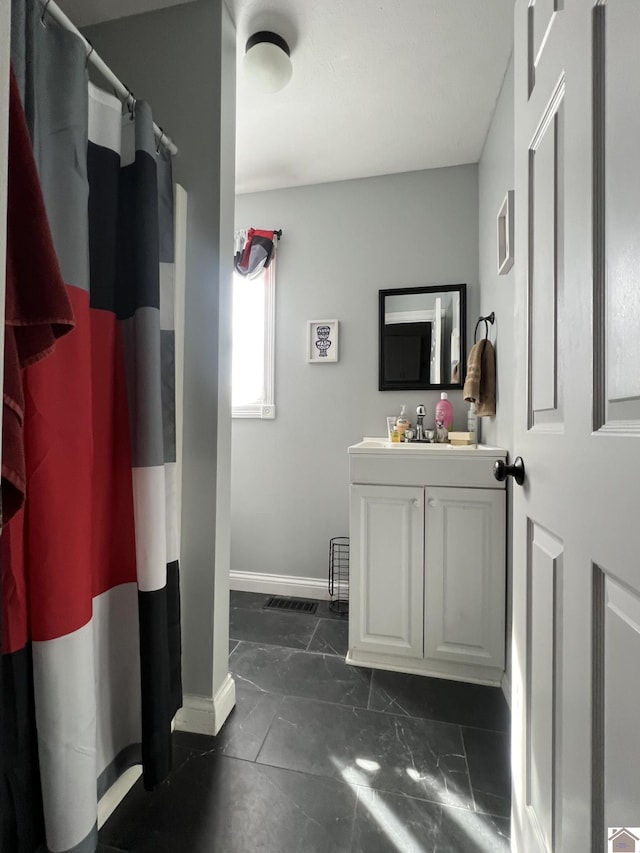 full bath with a shower with curtain, marble finish floor, vanity, and baseboards