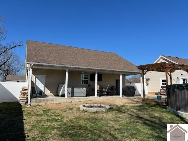 back of property with fence, roof with shingles, a lawn, a deck, and a pergola