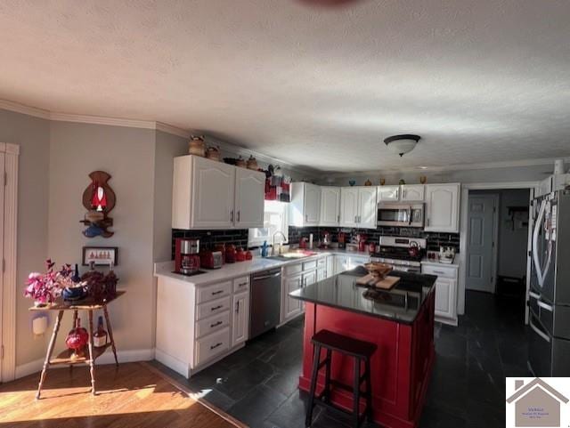 kitchen featuring stainless steel appliances, a kitchen island, white cabinets, and decorative backsplash