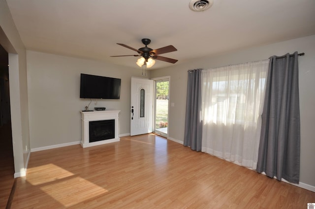 unfurnished living room with visible vents, a fireplace, light wood-type flooring, and baseboards