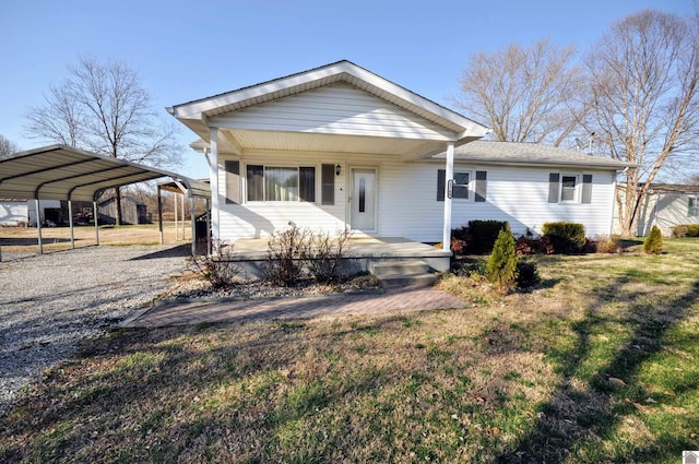 view of front of house with a porch, driveway, a detached carport, and a front yard