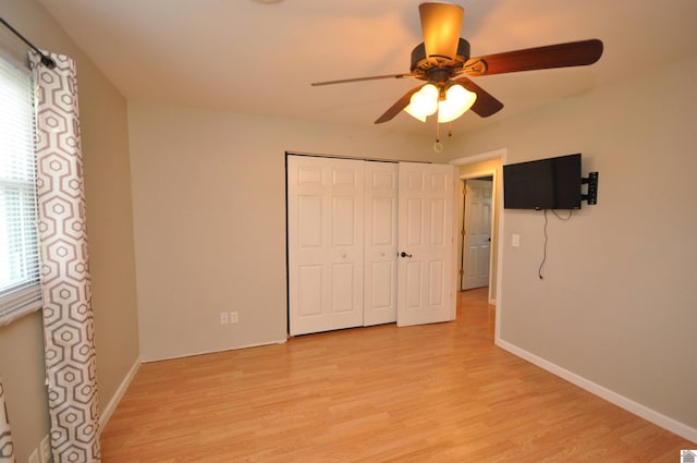 unfurnished bedroom with a closet, baseboards, and light wood finished floors