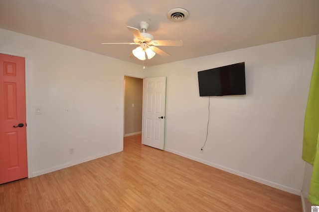 empty room featuring baseboards, visible vents, light wood finished floors, and ceiling fan