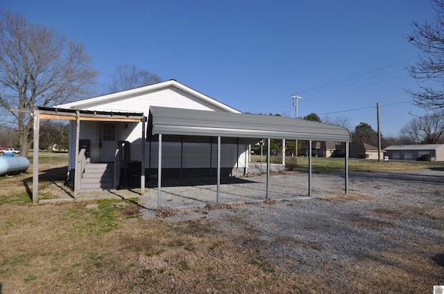 view of outdoor structure featuring a detached carport and gravel driveway