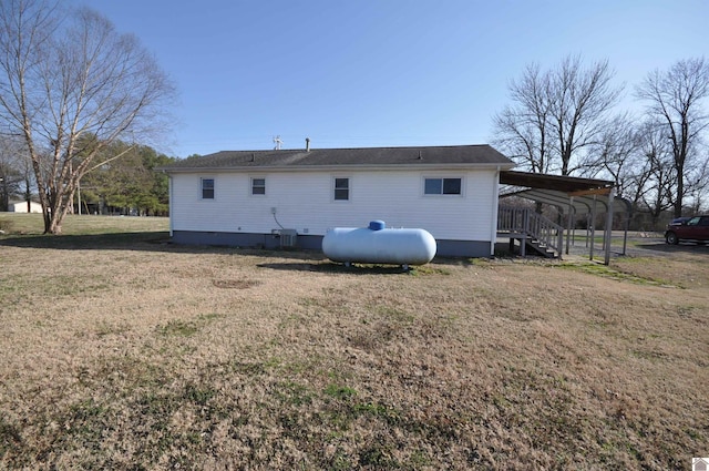 rear view of house featuring a carport and a lawn