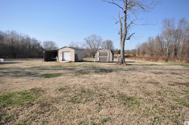 view of yard featuring an outbuilding, driveway, and a detached garage