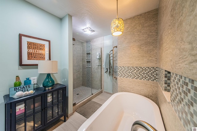 bathroom with a shower stall and a freestanding bath