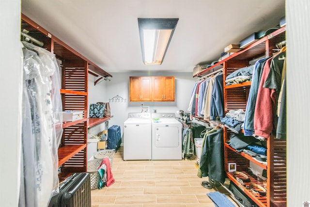 washroom with cabinet space, wood finish floors, and separate washer and dryer