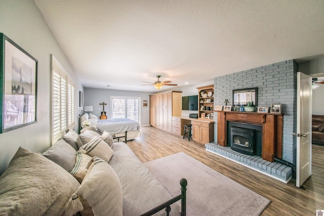 living area featuring light wood finished floors, a textured ceiling, and ceiling fan