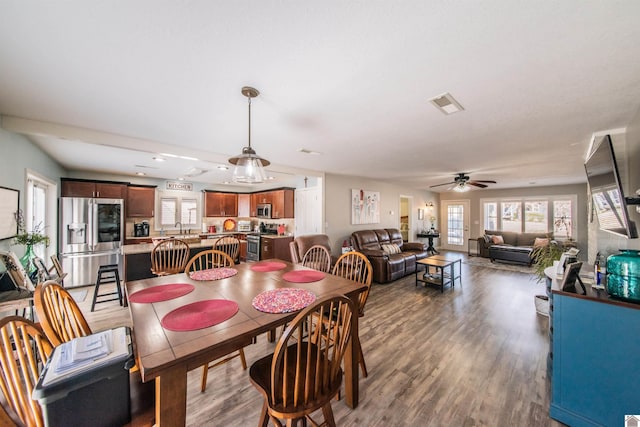 dining room with ceiling fan, visible vents, and wood finished floors