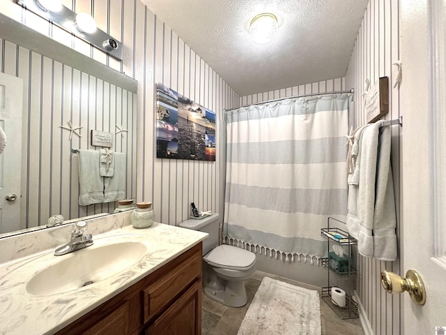 bathroom with toilet, wallpapered walls, a textured ceiling, and vanity